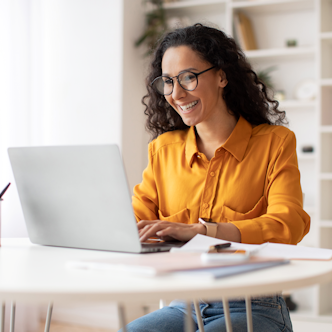 vrouw gele blouse achter laptop